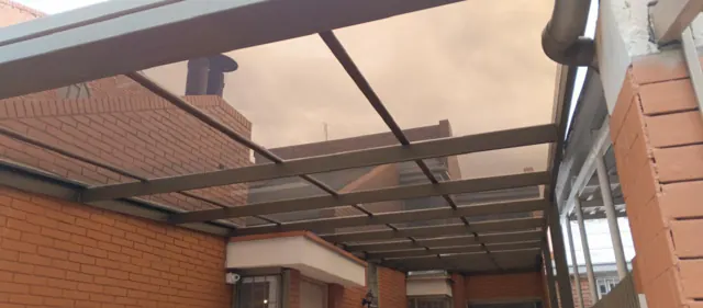 Marquesina en policarbonato con estructura metálica sobre terraza en ladrillo — Bogotá