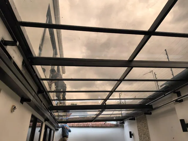 Marquesina en policarbonato bronce sobre terraza — Bogotá