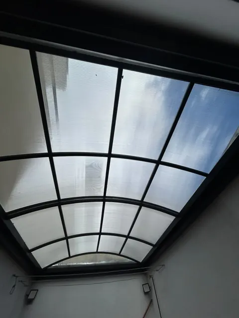 Marquesina curva en policarbonato con estructura metálica negra — Bogotá