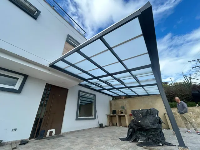 Marquesina en policarbonato con estructura negra sobre terraza de vivienda — Bogotá