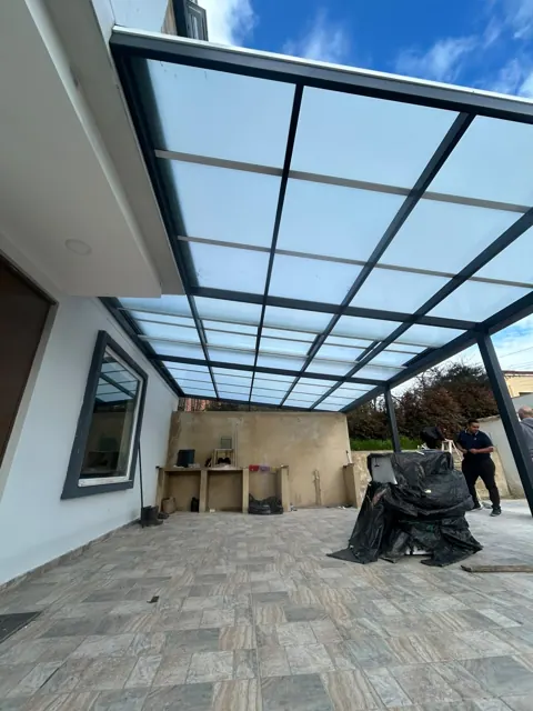 Marquesina en policarbonato sobre terraza con acceso a jardín — Bogotá