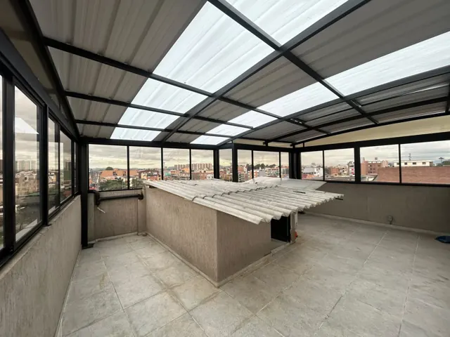 Cubierta en policarbonato sobre terraza con barra y vista a la ciudad — Bogotá