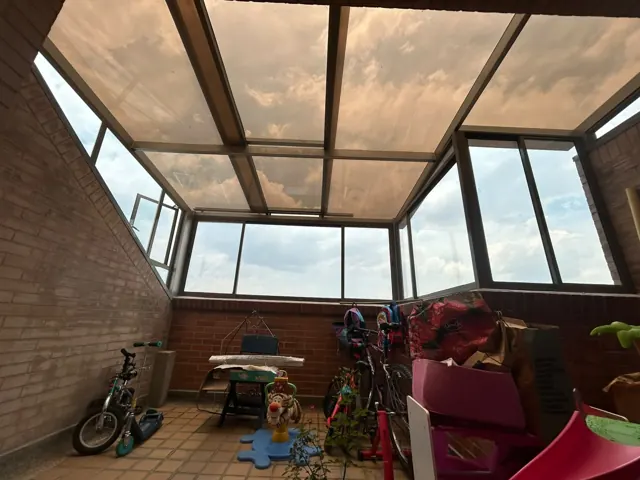 Cerramiento de terraza en policarbonato y vidrio con estructura negra — Bogotá