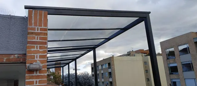 Marquesina en policarbonato con estructura en acero sobre ladrillo — Bogotá