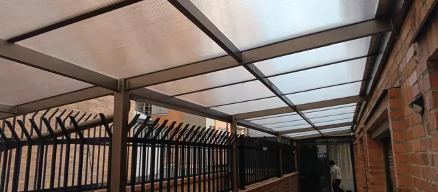 Marquesina en policarbonato sobre balcón en ladrillo — Bogotá