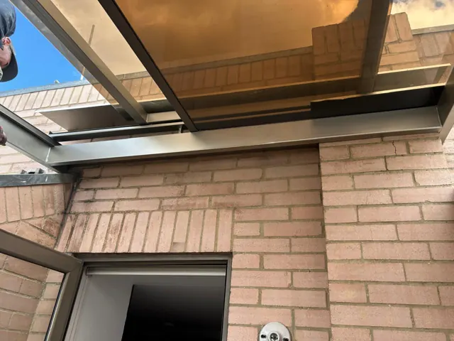 Marquesina en policarbonato sobre entrada en ladrillo — Bogotá