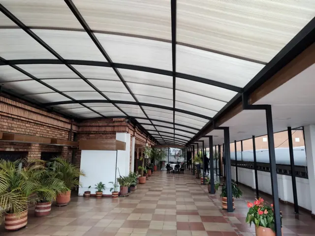 Marquesina en policarbonato sobre terraza con piso en madera — Bogotá