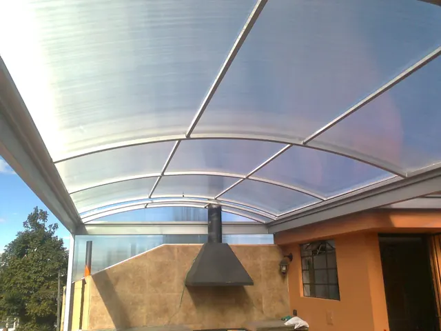 Marquesina curva en policarbonato sobre terraza — Bogotá