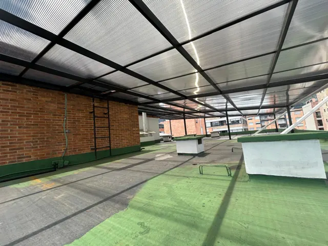 Marquesina en policarbonato sobre terraza con césped sintético — Bogotá