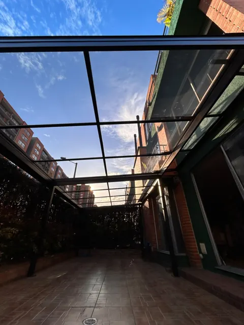 Marquesina en vidrio sobre patio interior de vivienda — Bogotá
