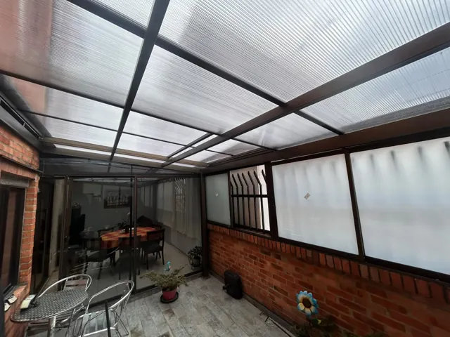 Cerramiento de terraza en policarbonato con comedor exterior — Bogotá