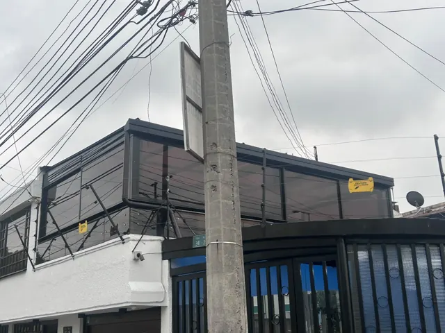 Marquesina en vidrio sobre balcón de vivienda con baranda — Bogotá