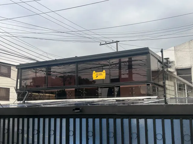 Marquesina en vidrio con baranda metálica sobre balcón — Bogotá